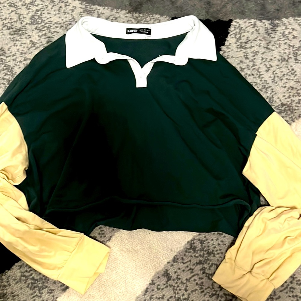 A white collared , dark green , and beige long sleeved crop top
